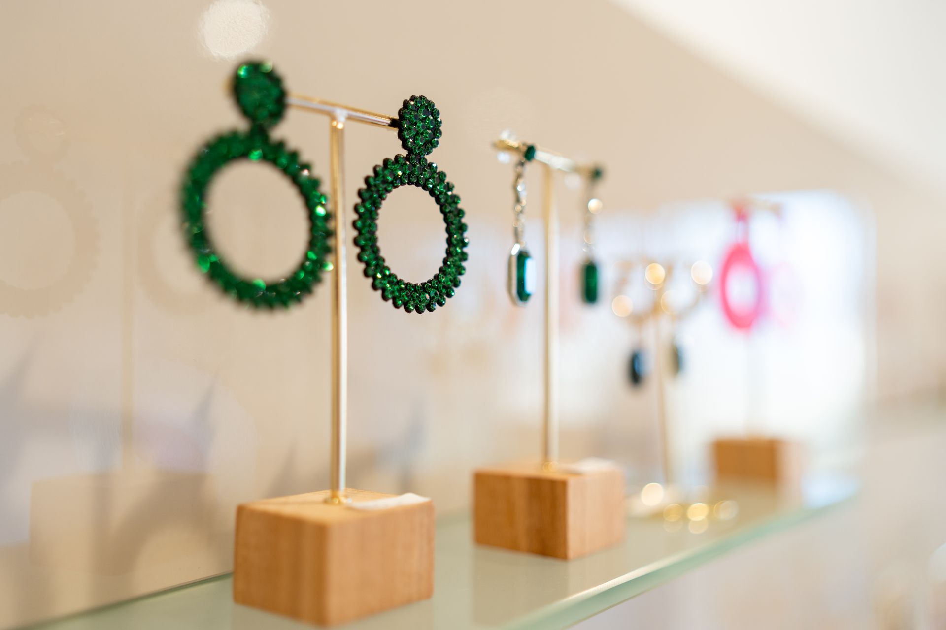 Grüne Schmuckohrringe auf Verkaufsständern, Einzelhandelsumgebung.