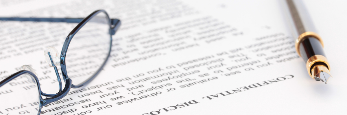 A pair of glasses and a pen are sitting on top of a piece of paper.