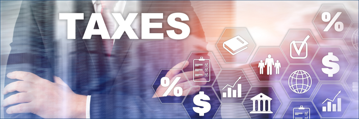 A man in a suit is standing in front of a screen that says taxes.