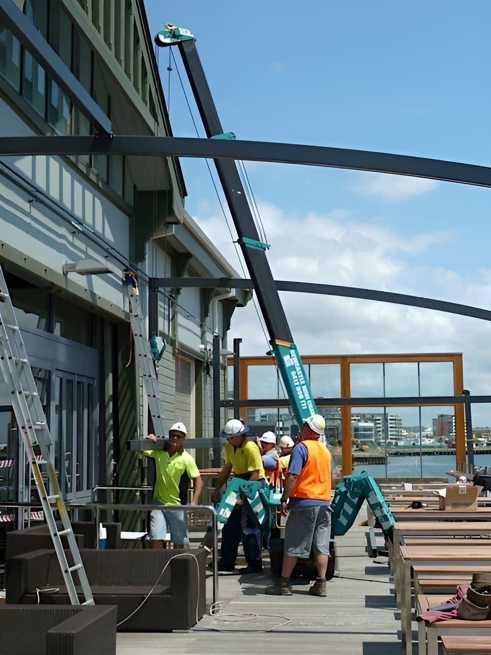 A Group Of Construction Workers Are Working On A Building — Newcastle Cranes In Cardiff, NSW