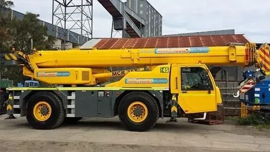 A Green Crane With the Number 37 on It is Parked in Front of a Building — Newcastle Cranes In Cardiff, NSW