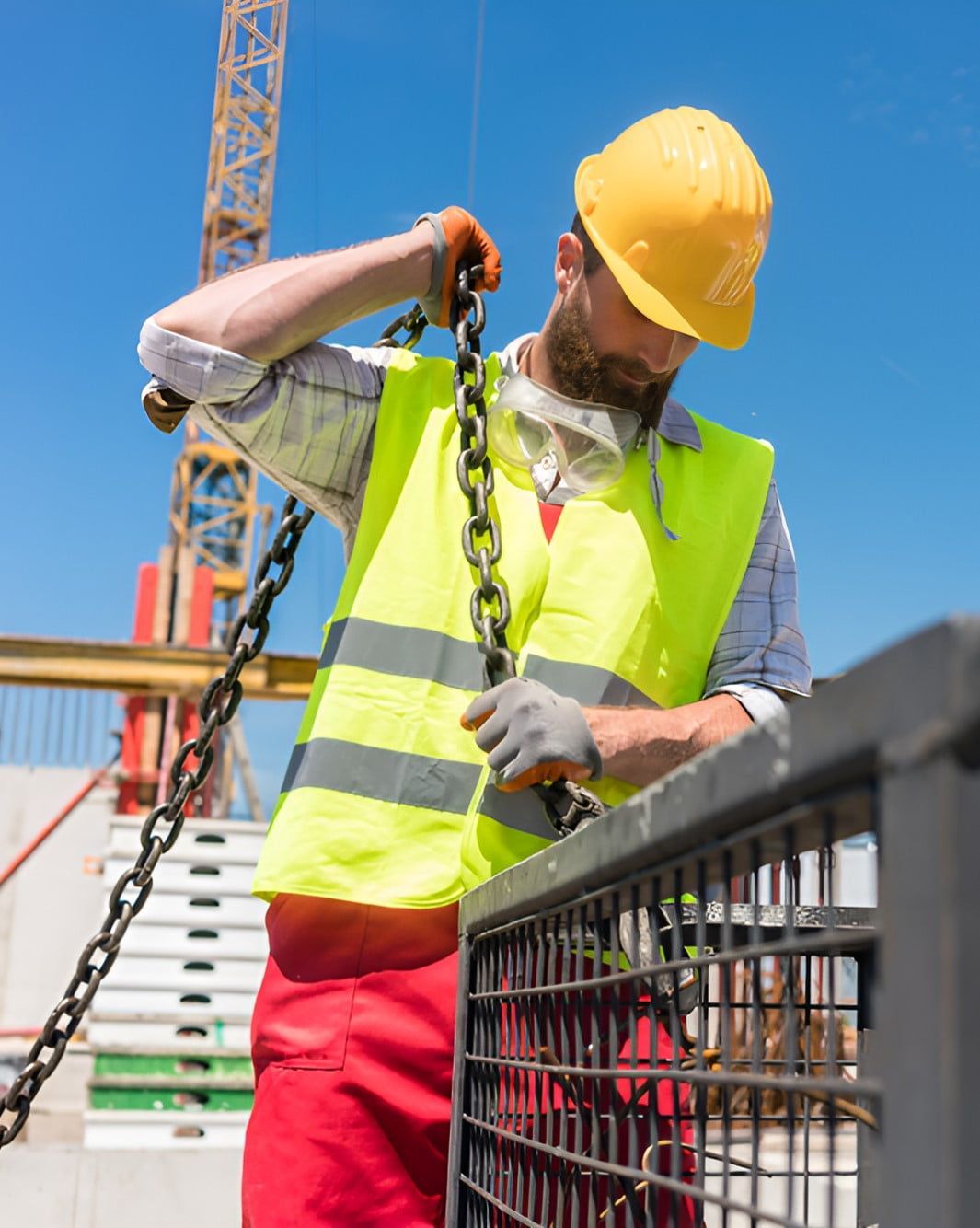 A Construction Worker Wearing A Hard Hat And Safety Vest Is Holding A Chain — Newcastle Cranes In Hunter Valley, NSW