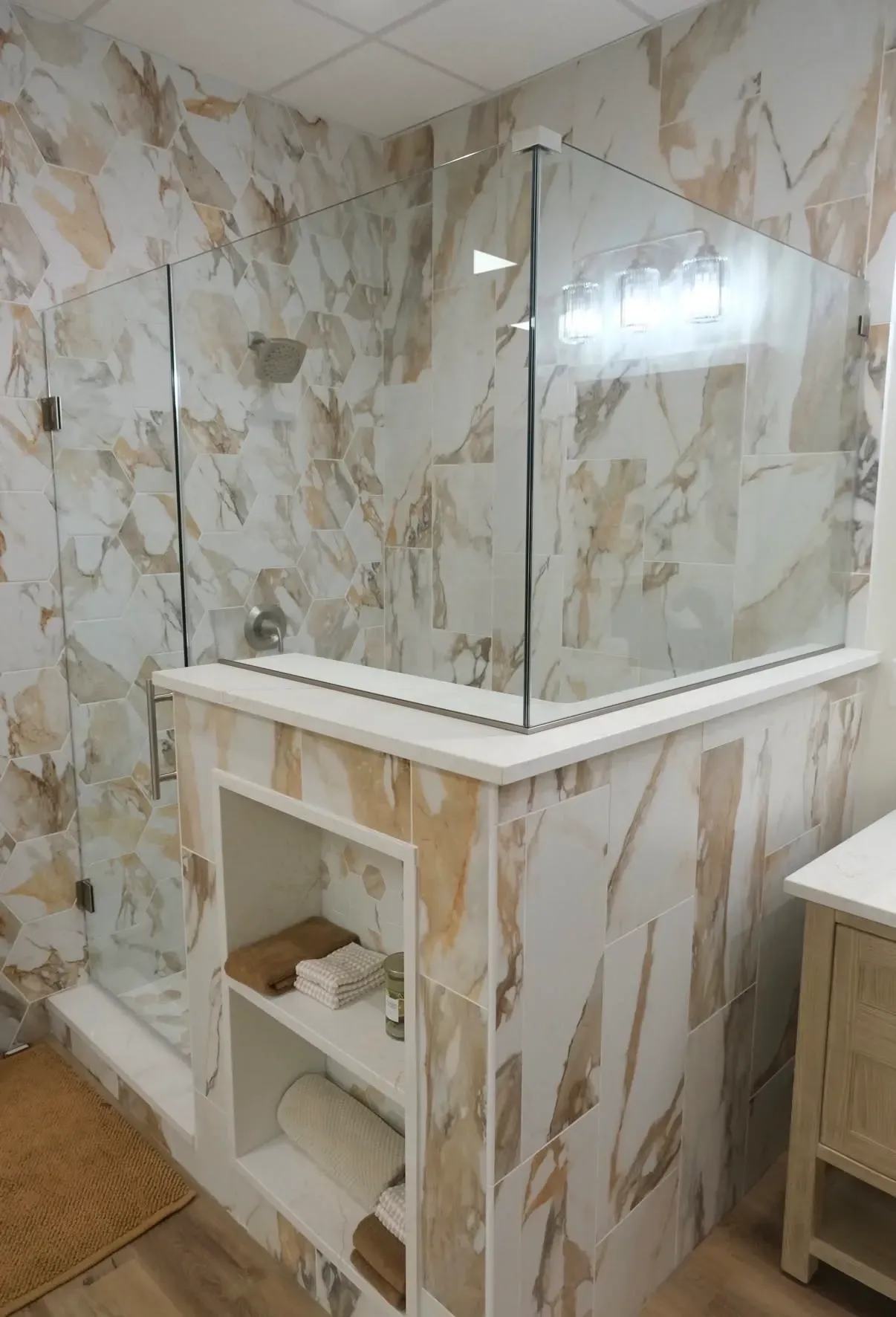 Shower surround with large-format porcelain tile and frameless glass enclosure