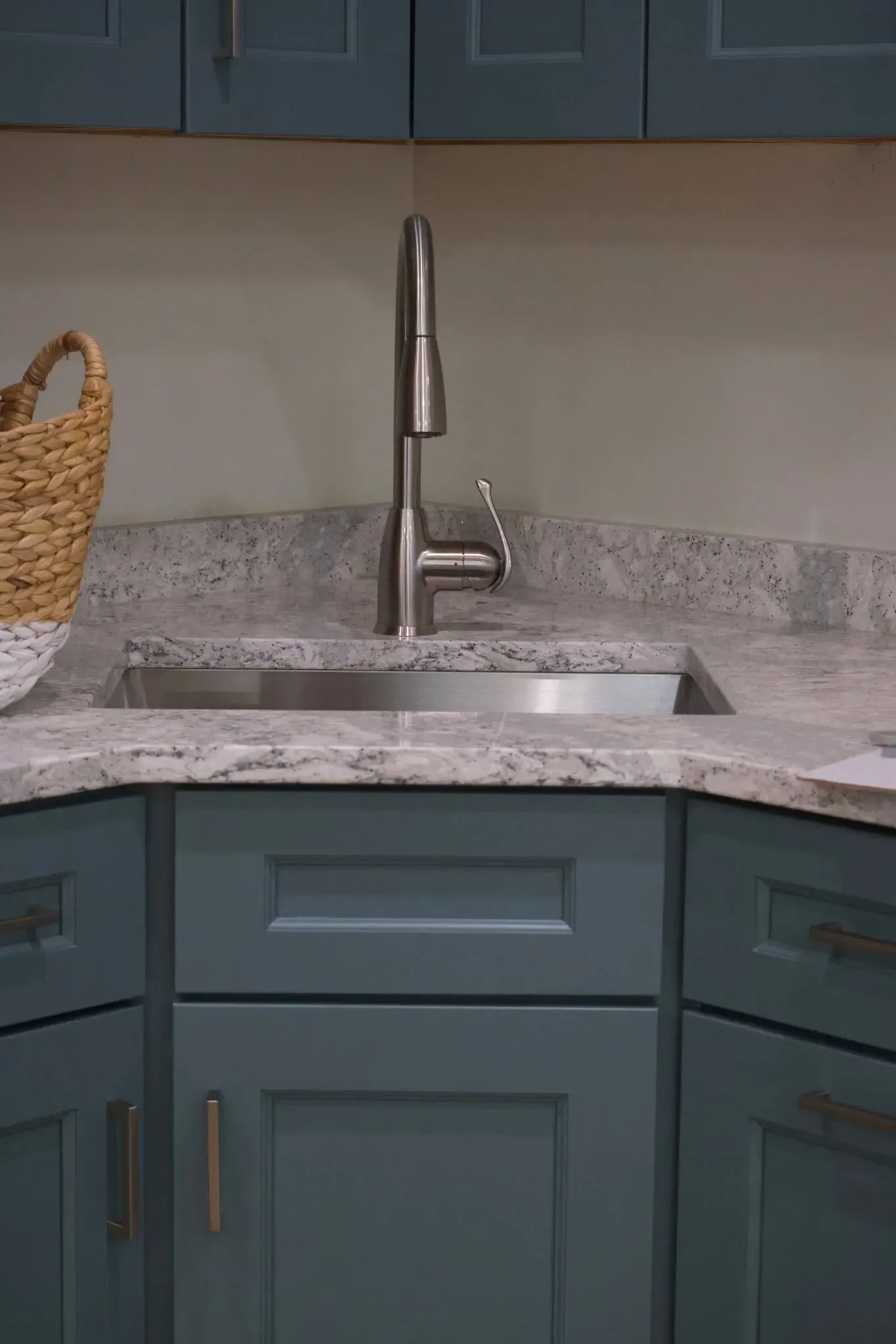 Luxury dark navy Shaker-style kitchen with brass hardware and waterfall countertop