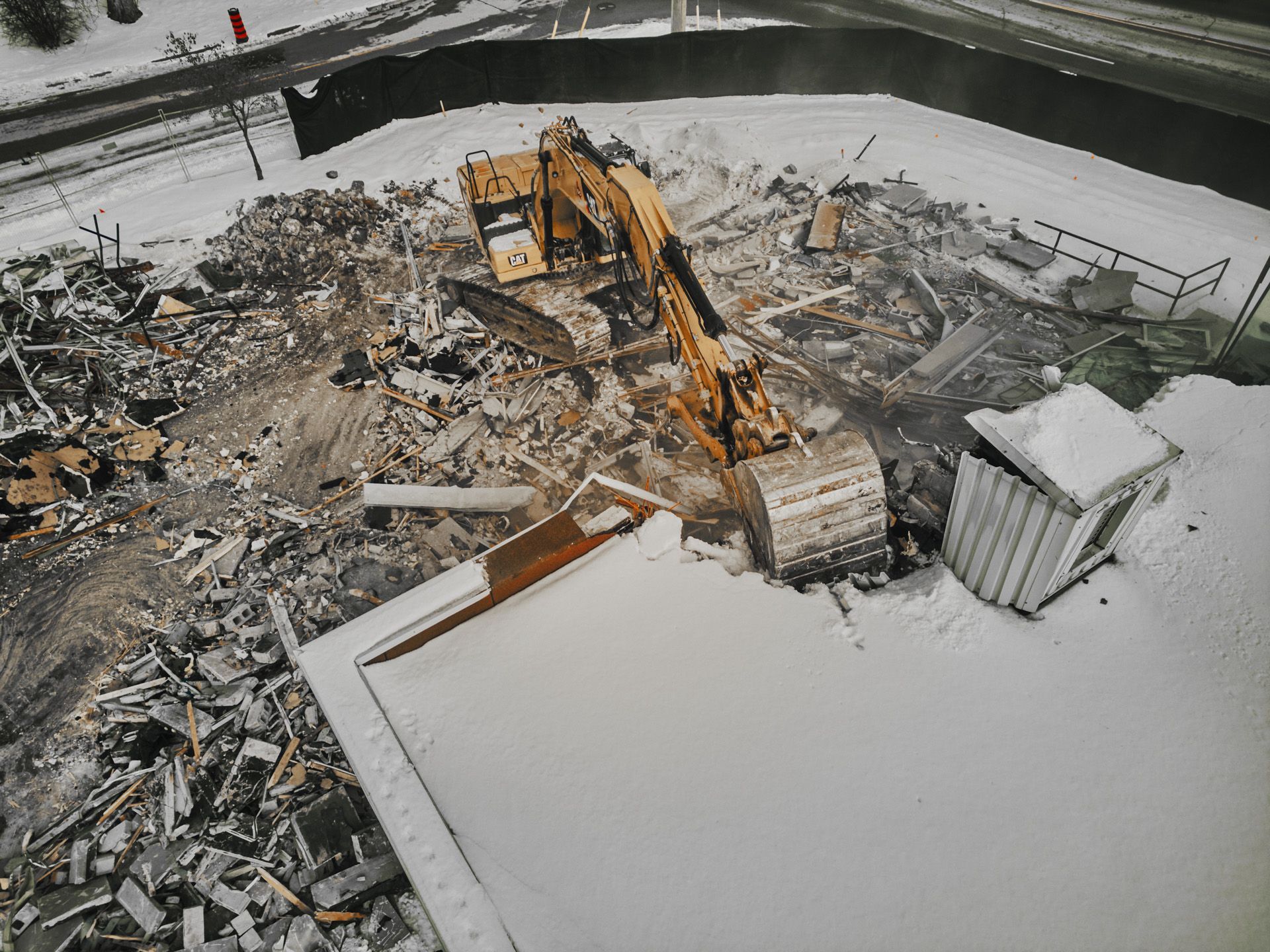 An aerial view of a building being demolished in the snow