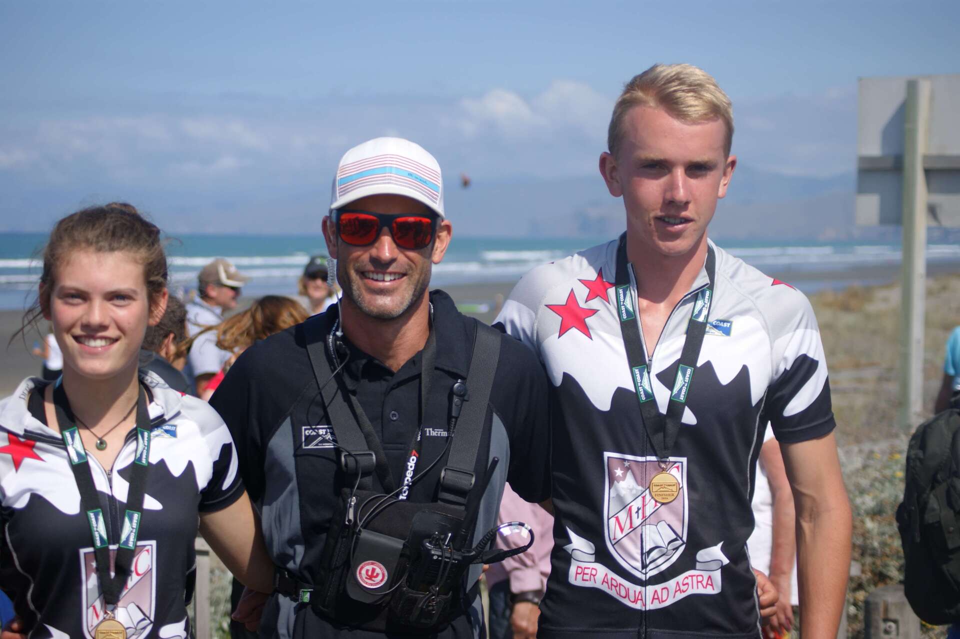 A group of people standing next to each other with medals around their necks.