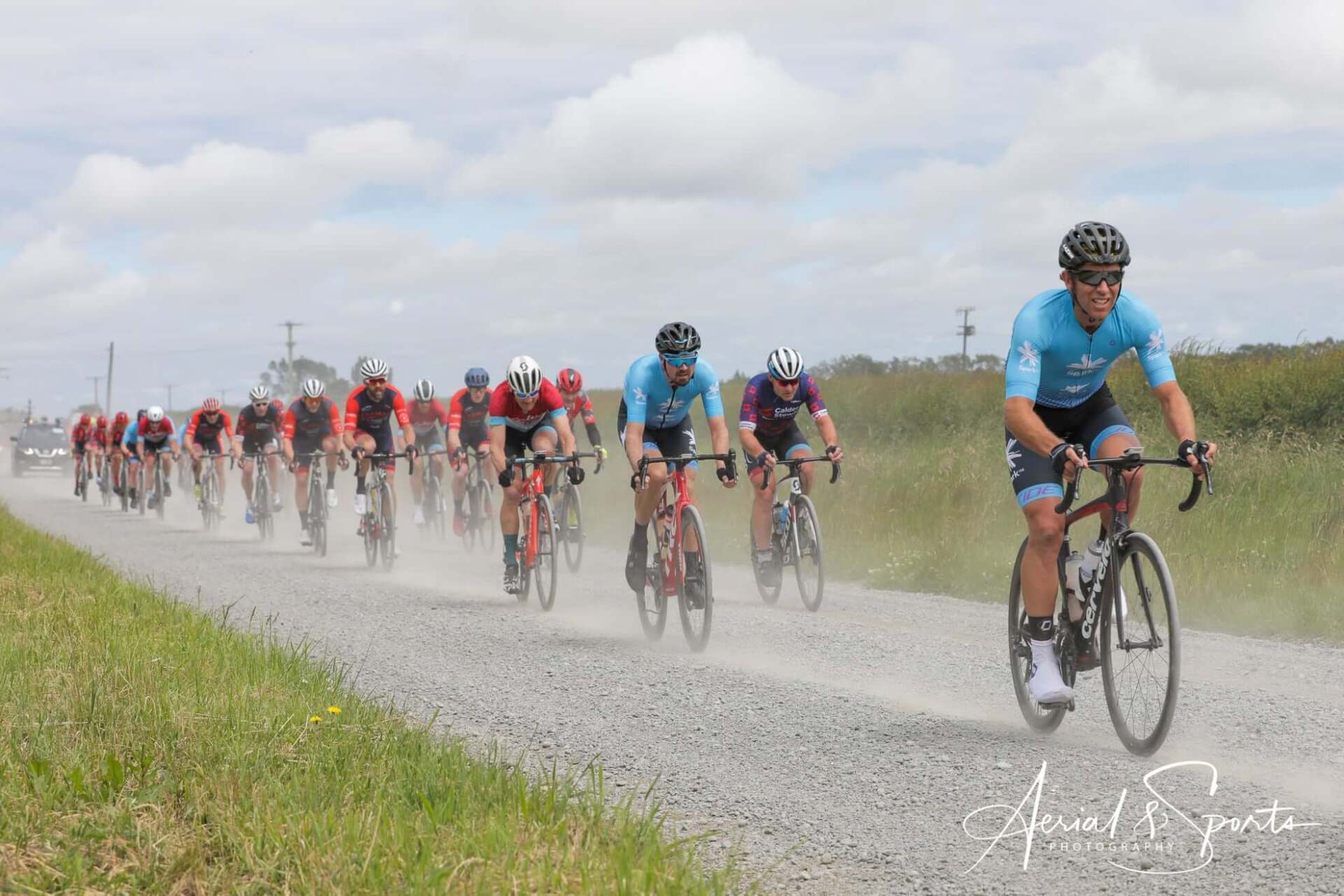 A group of people are riding bicycles down a dirt road.