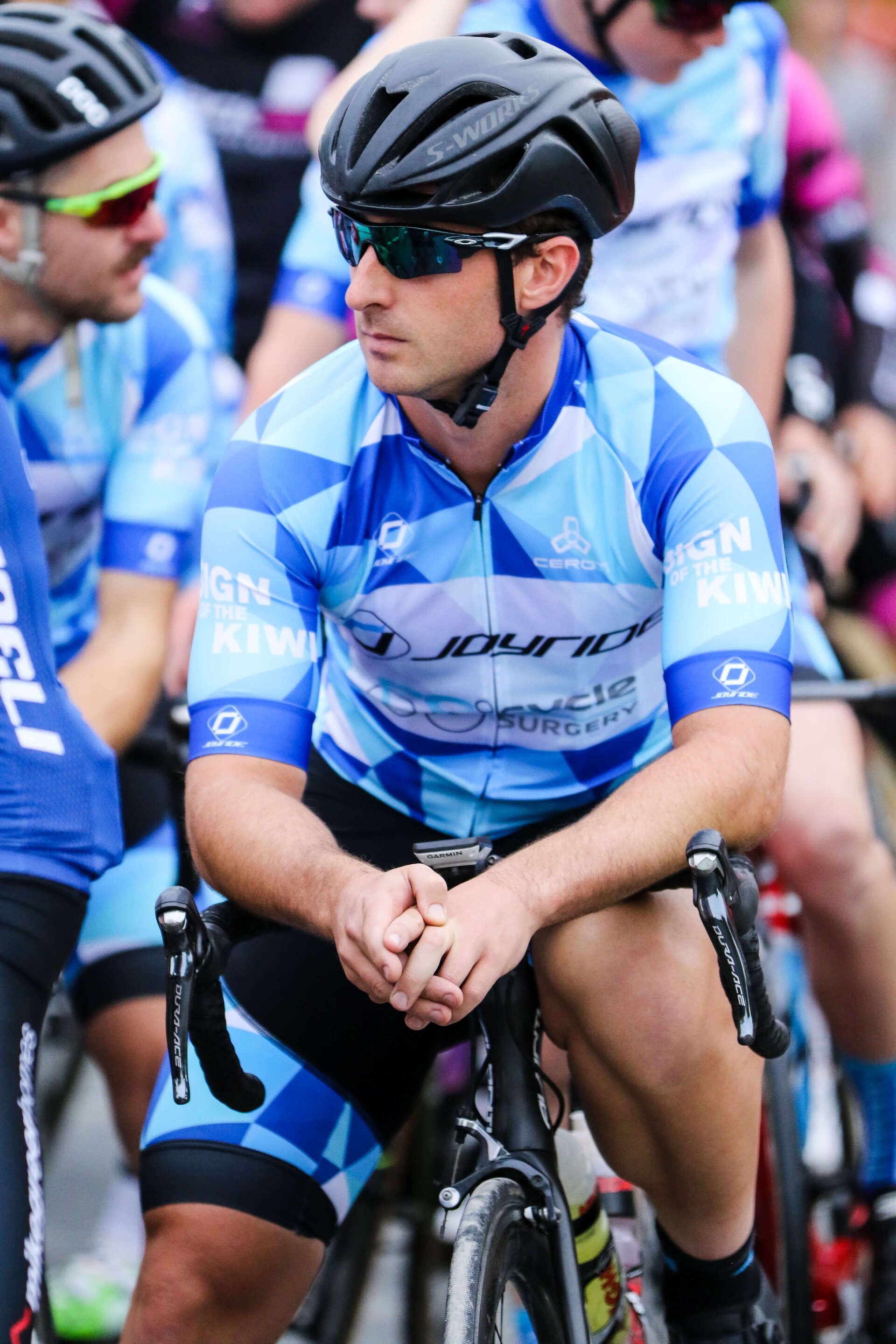A man wearing a helmet and sunglasses is sitting on a bicycle.