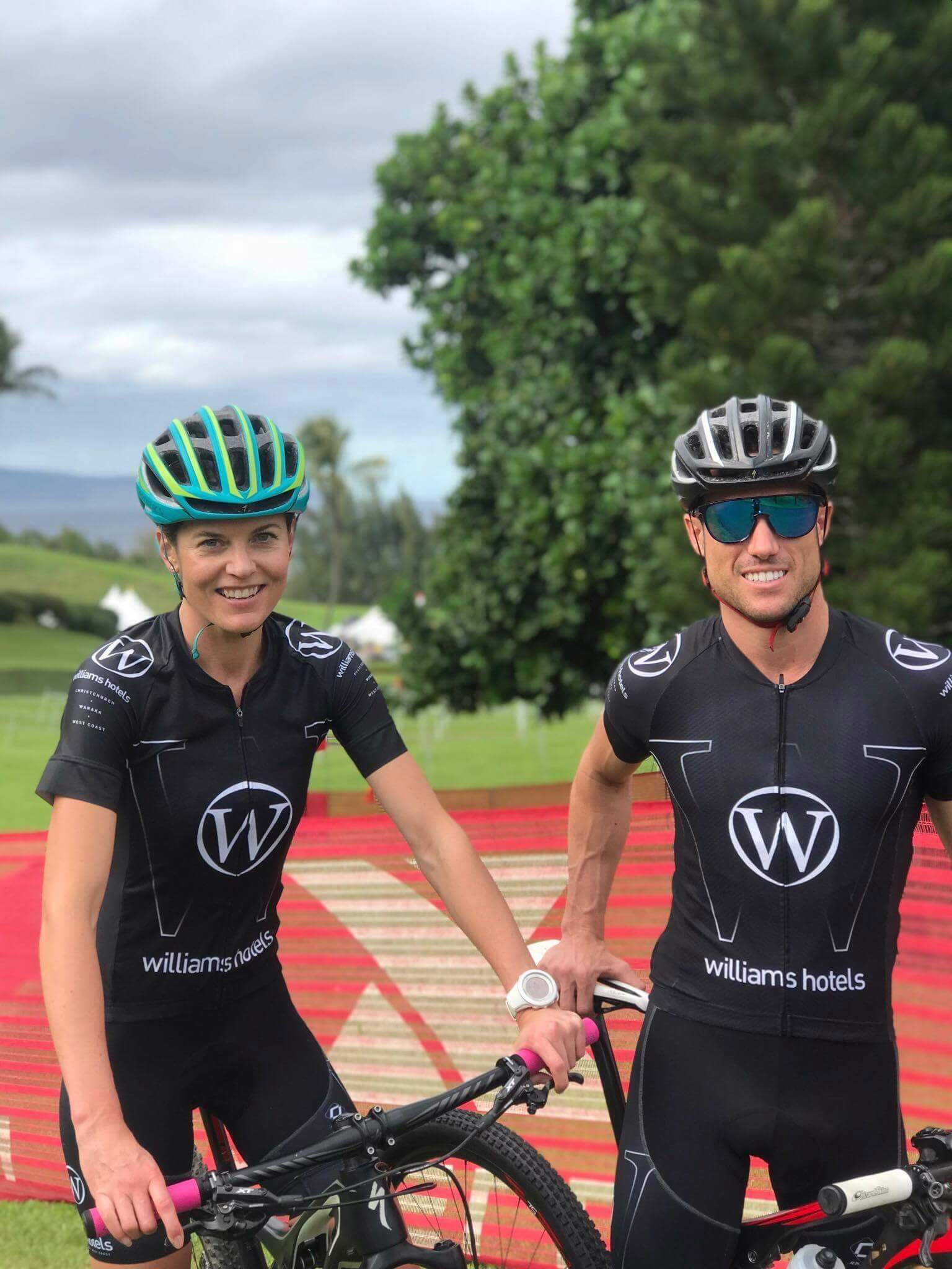 A man and a woman are standing next to each other with bicycles.