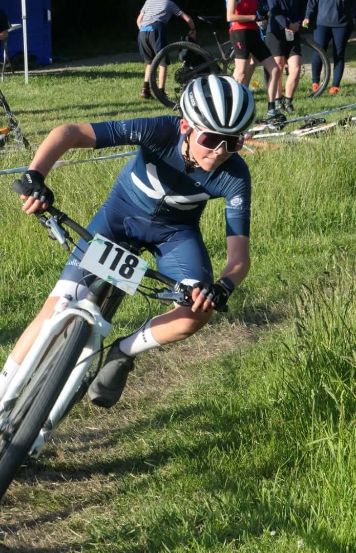 A man is riding a bike on a grassy field.