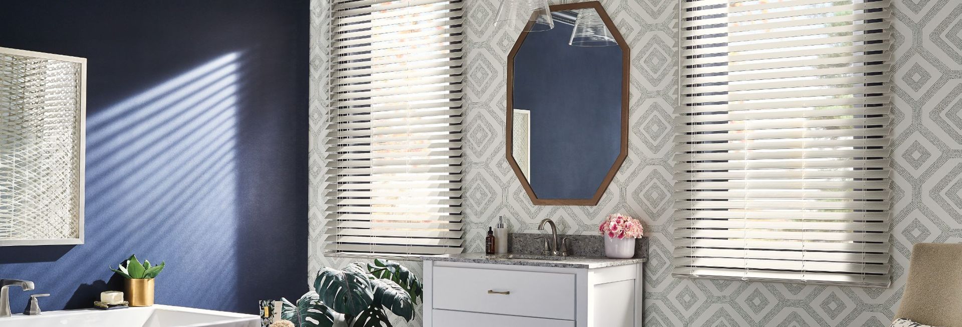 A bathroom with a sink , mirror , and window blinds.