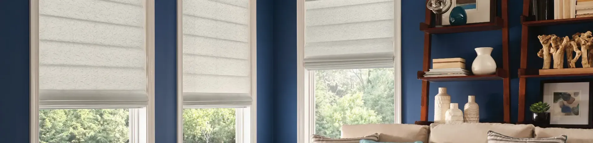 A living room with blue walls and white blinds on the windows.