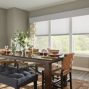 A dining room with a table and chairs and a bench.