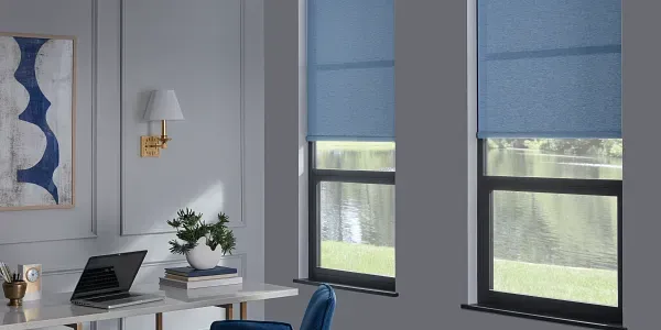 A room with two windows and a desk with a laptop on it.
