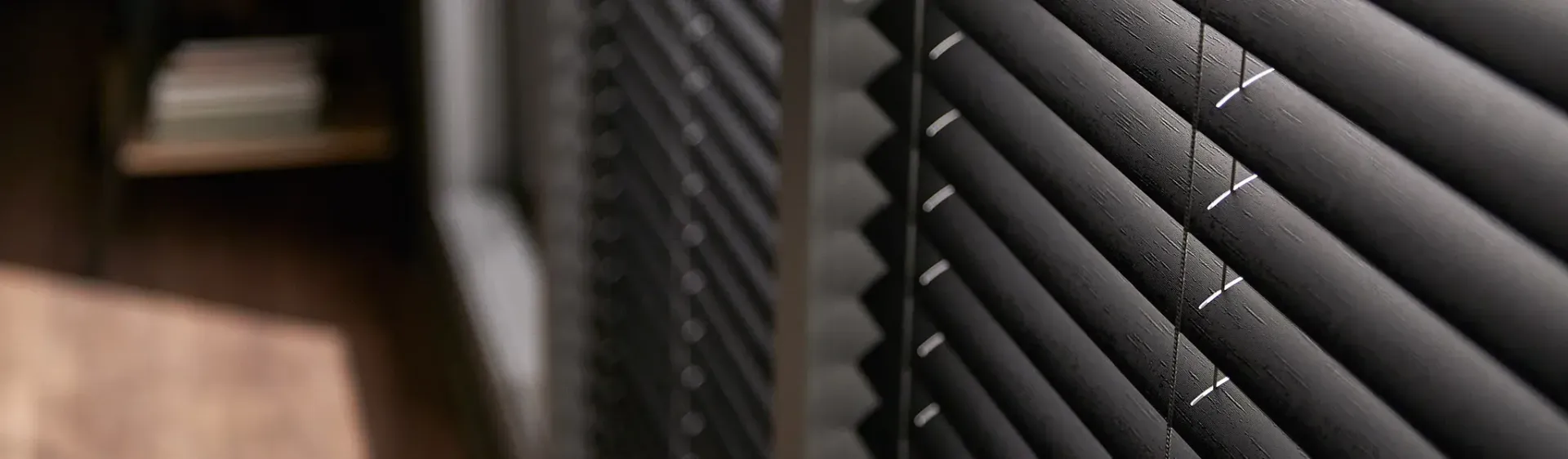 A close up of a pair of black blinds on a window.