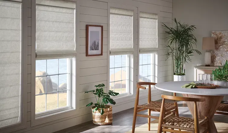 A dining room with a table and chairs and a potted plant.