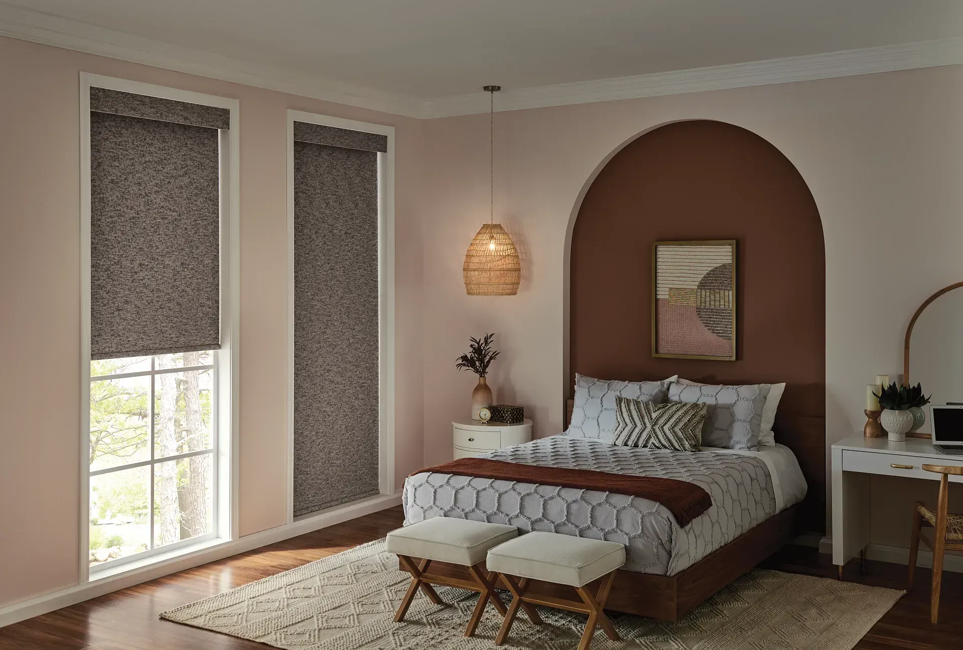 A bedroom with a bed , a desk , and two windows.