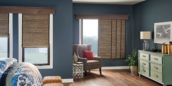 A bedroom with blue walls , wooden floors , a bed , chair and dresser.