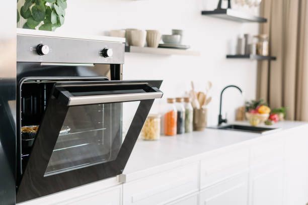An oven is open in a kitchen with the door open.