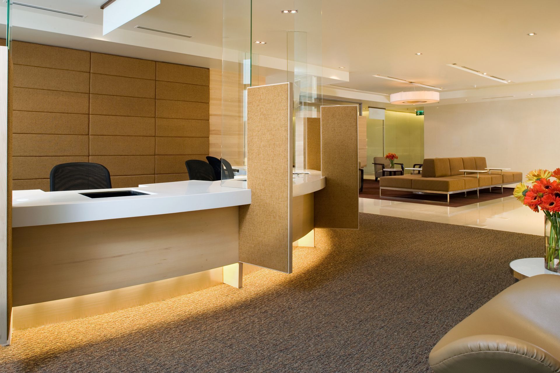 A reception area with a desk and a vase of flowers