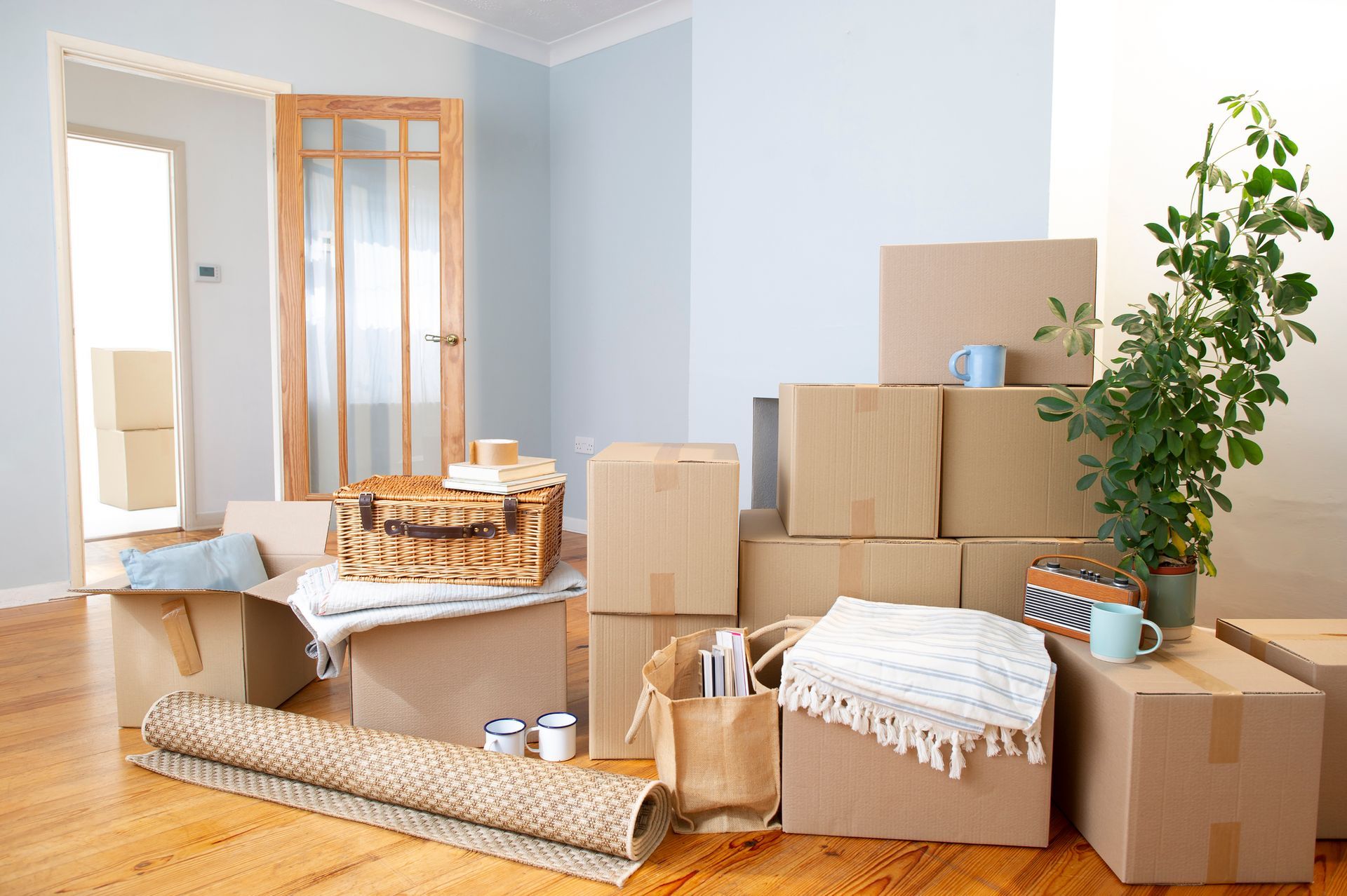 A living room filled with cardboard boxes and a rug.