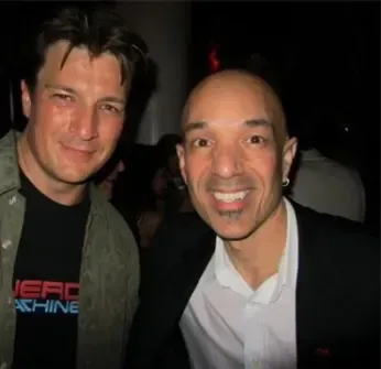 Two men posing for a picture with one wearing a shirt that says zero machine
