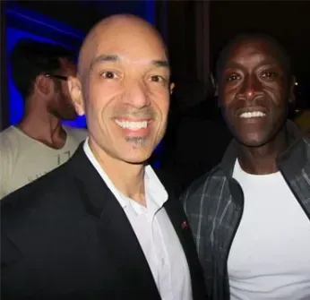 Two men are posing for a picture and smiling for the camera