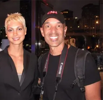 A man with a canon camera strap stands next to a woman