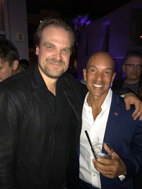 Two men are posing for a picture and one is holding a drink