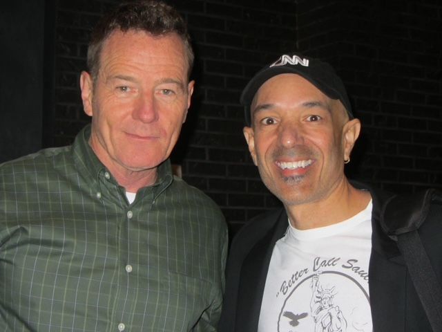 Two men are posing for a picture and one of them is wearing a boston eagles shirt