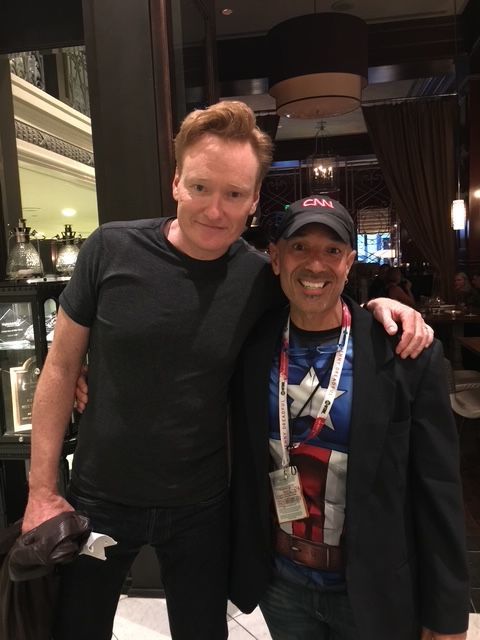 Two men are posing for a picture and one of them is wearing a captain america shirt