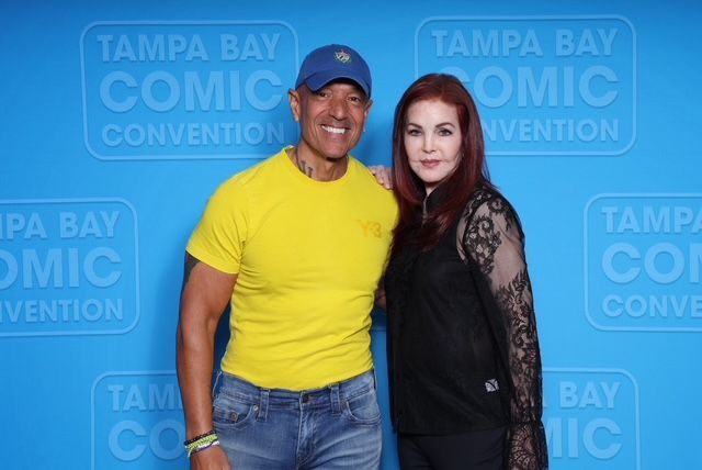 A man and a woman are posing for a picture at tampa bay comic convention