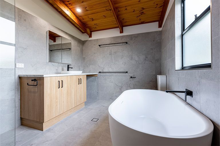 A bathroom with a bathtub , sink and mirror.