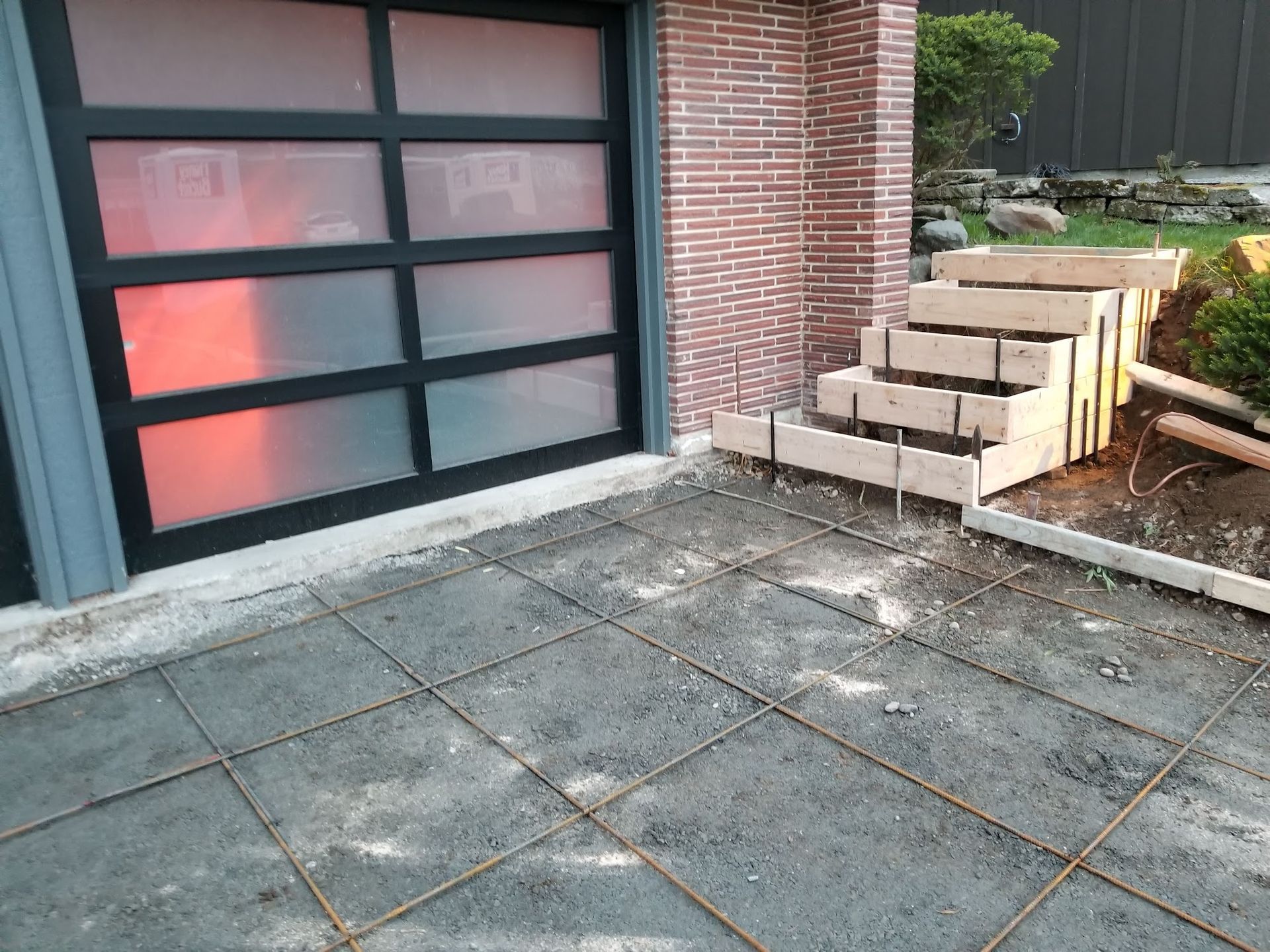 A concrete staircase is being built in front of a garage door.