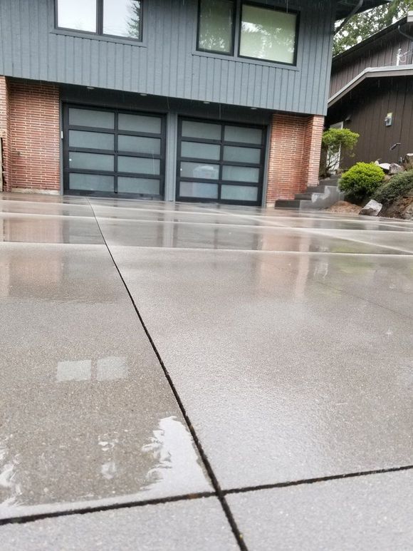 A concrete patio is being built in front of a house.