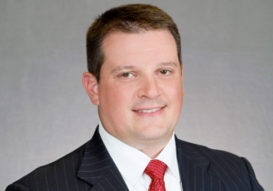 A man in a suit and tie is smiling for the camera.