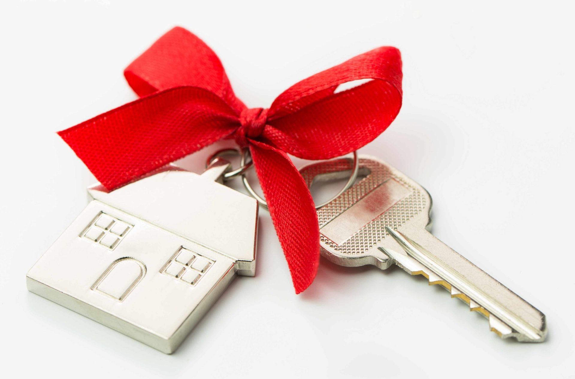 White house keychain with red ribbon tied to two keys on a white background