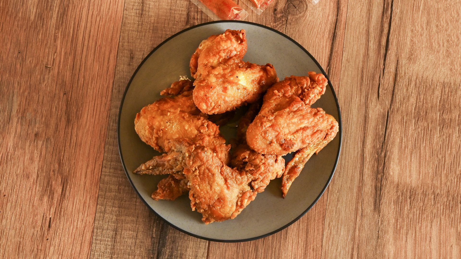 Plate of crispy fried chicken pieces on a wooden table