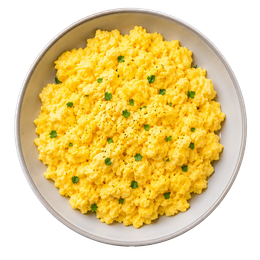 Ciotola di uova strapazzate gialle guarnite con erbe aromatiche