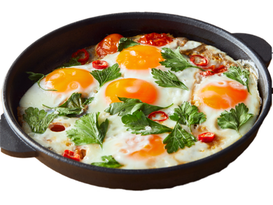 Padella di uova al forno con erbe aromatiche, pomodori e formaggio fuso su sfondo bianco.