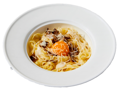 Pasta servita in una ciotola bianca con tuorlo d'uovo crudo, formaggio grattugiato e funghi.