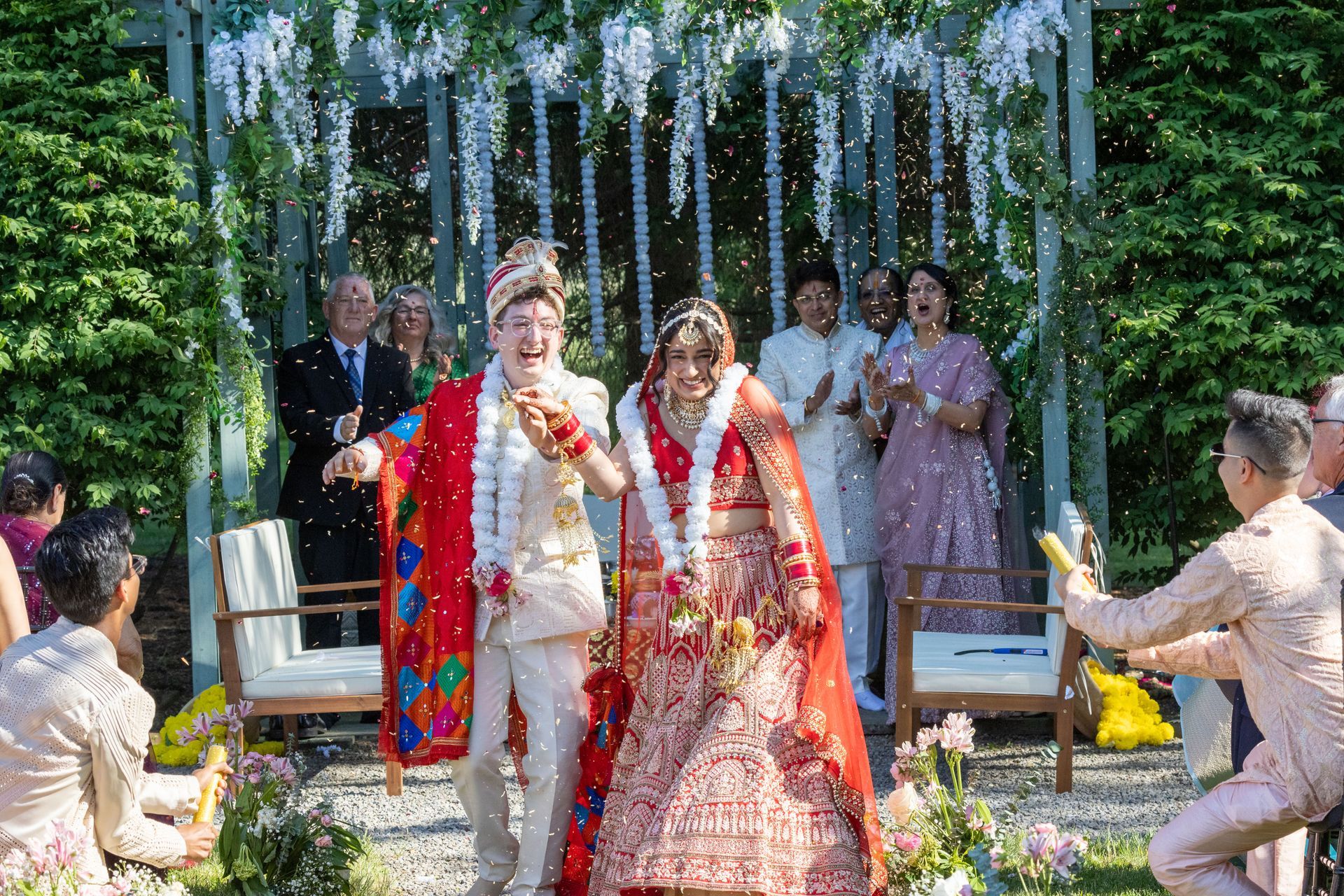 Young couple coming down the aisle on wedding day with bright colors and flowers