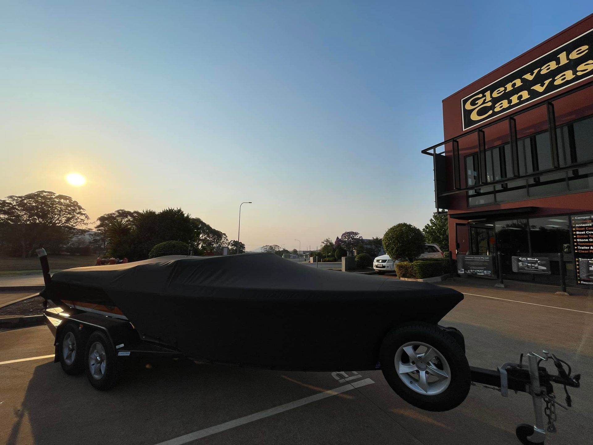 Boat on a Trailer is Covered in a Black Cover — Glenvale Canvas Pty Ltd in Wilsonton, QLD