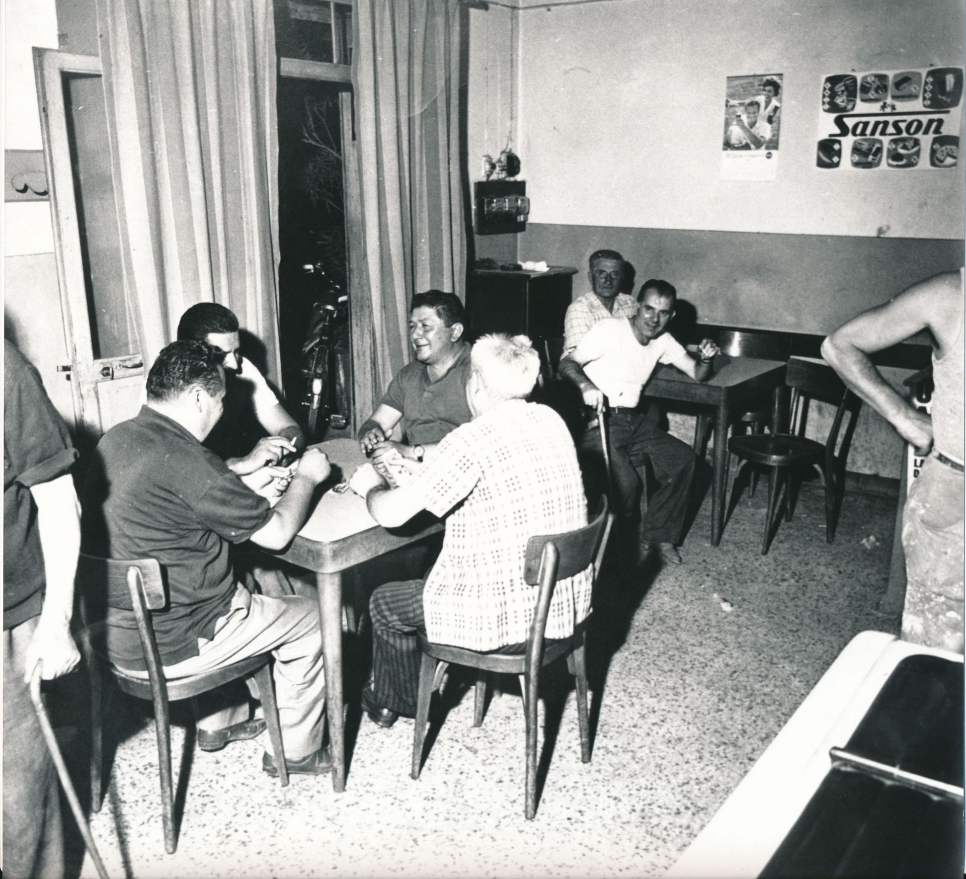 Una foto in bianco e nero di un gruppo di persone sedute ai tavoli