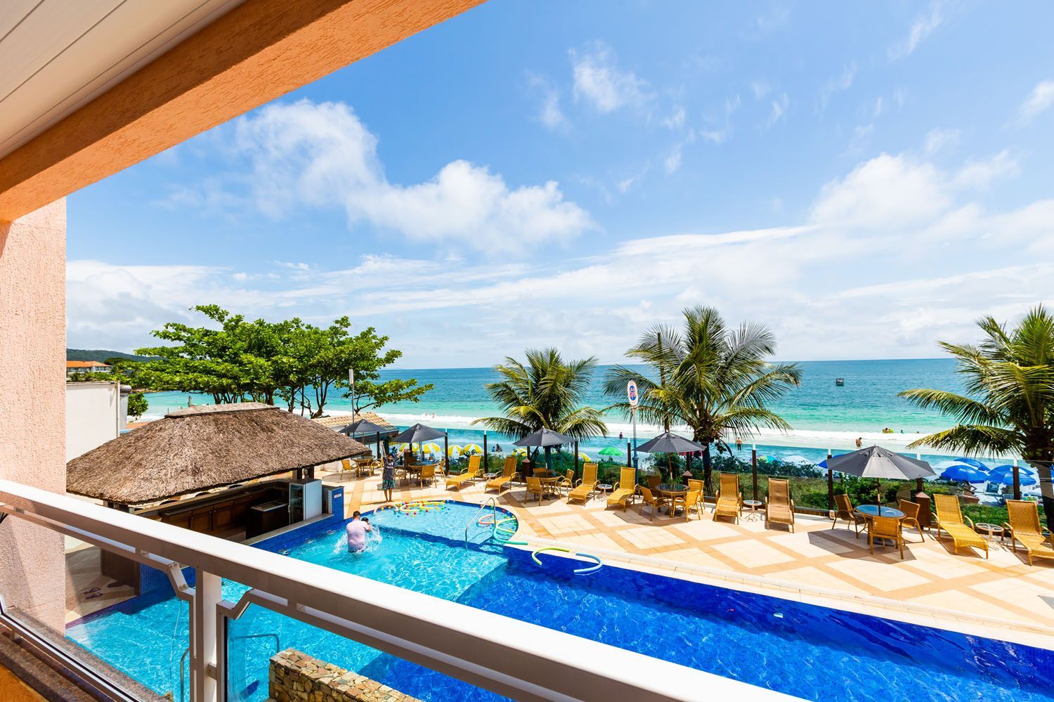 Vista de uma piscina e do oceano a partir de uma varanda