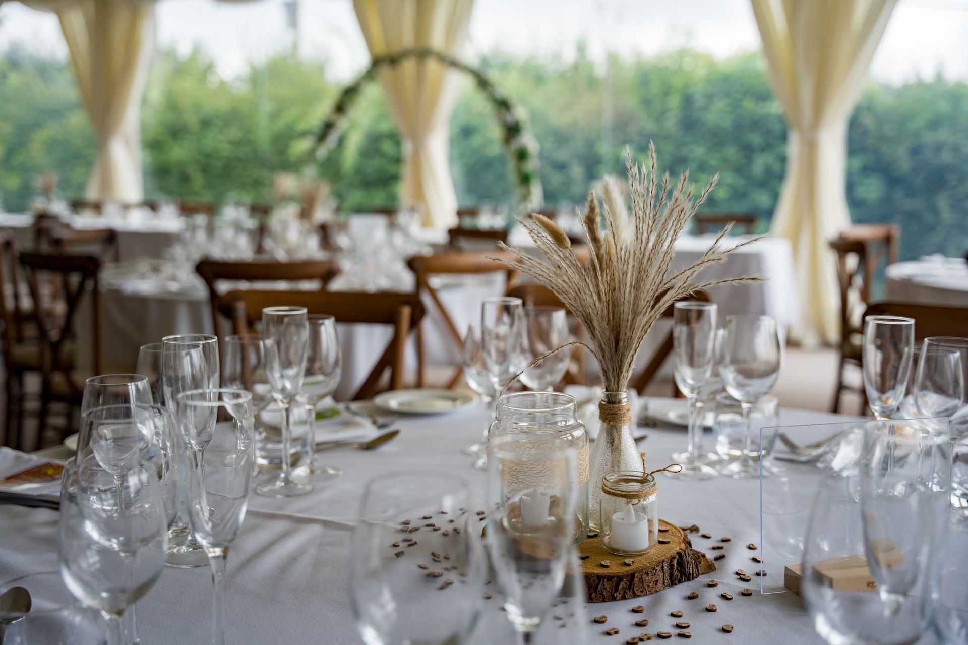 A table set for a wedding reception with a vase of flowers on it.