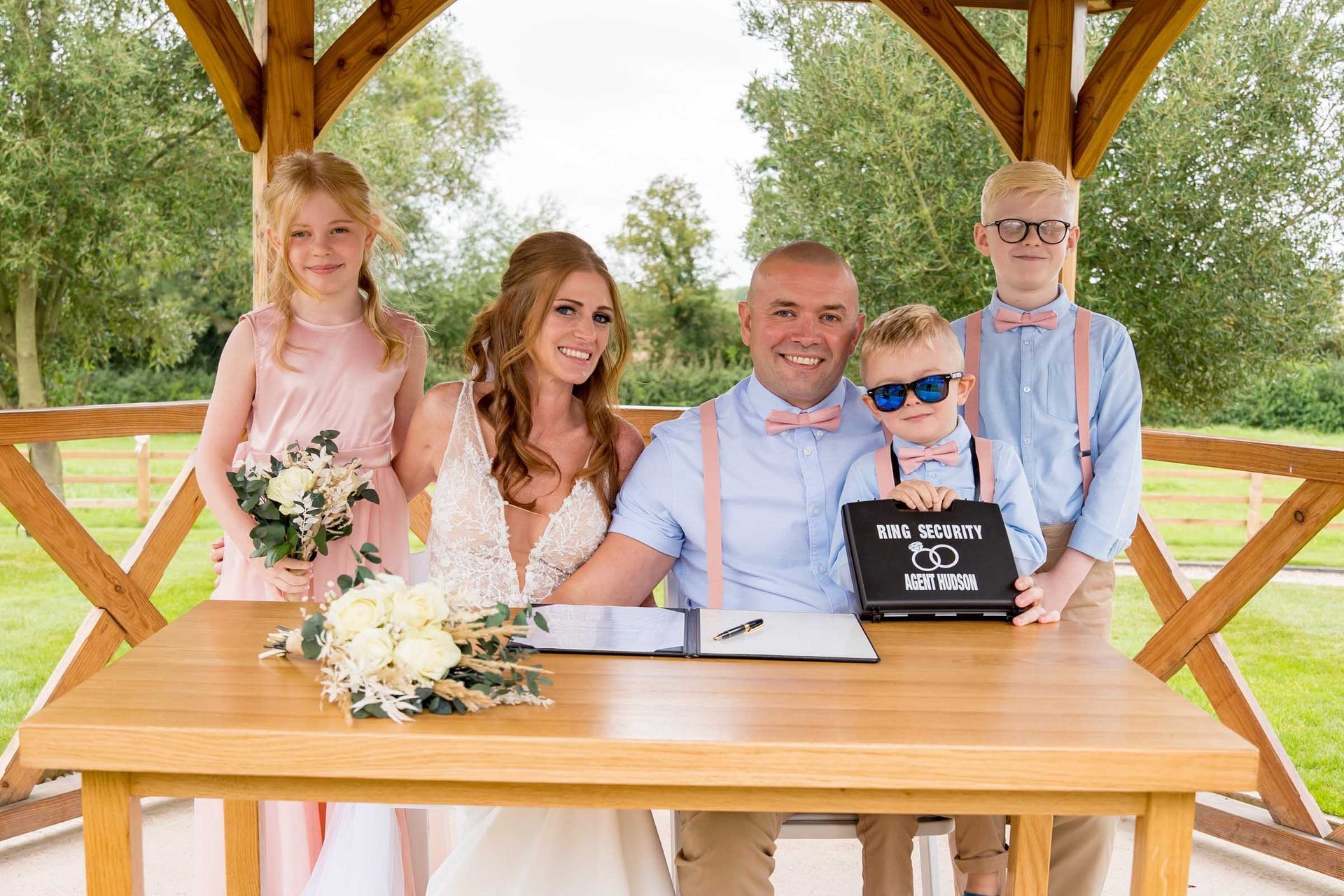 A bride and groom are sitting at a table with their children.