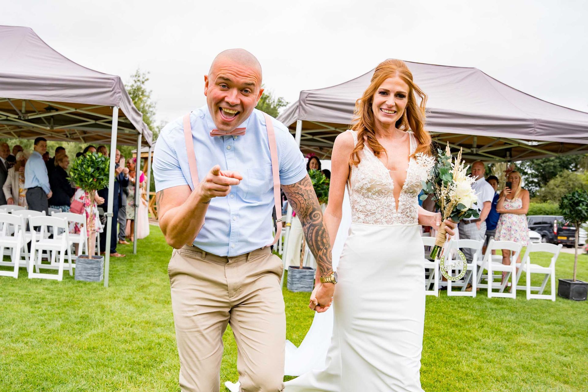 A bride and groom are walking down the aisle at their wedding.