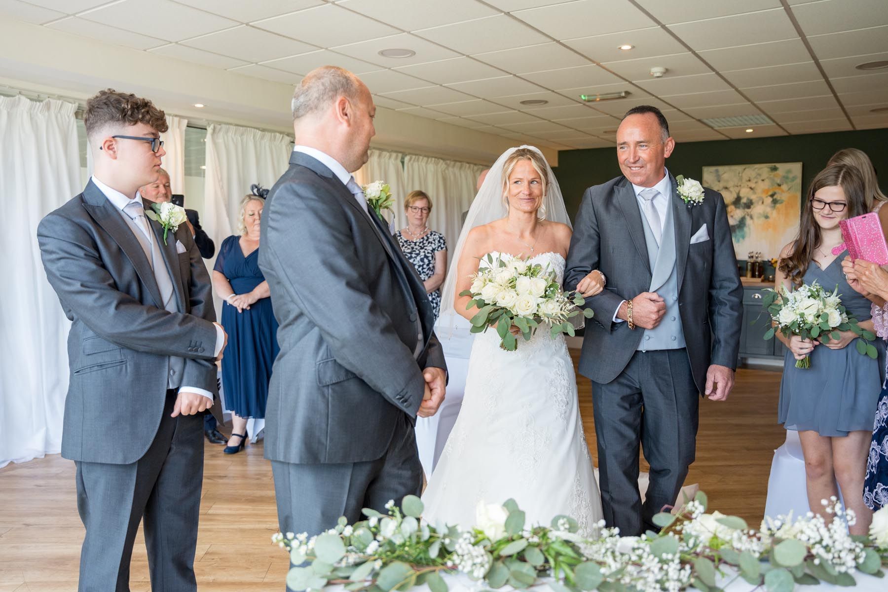 A bride and groom are walking down the aisle at their wedding ceremony.