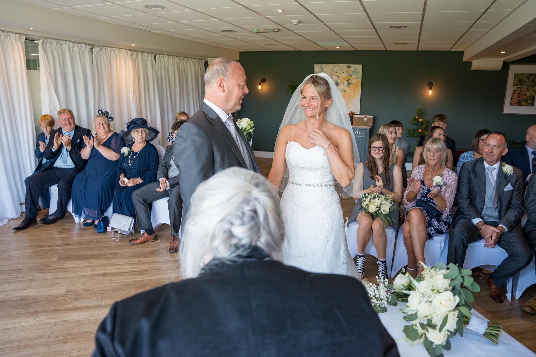 A bride and groom are walking down the aisle at a wedding ceremony.